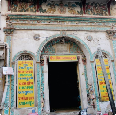 Jain temple entrance with colorful carvings and murals in Ahmedabad, India.