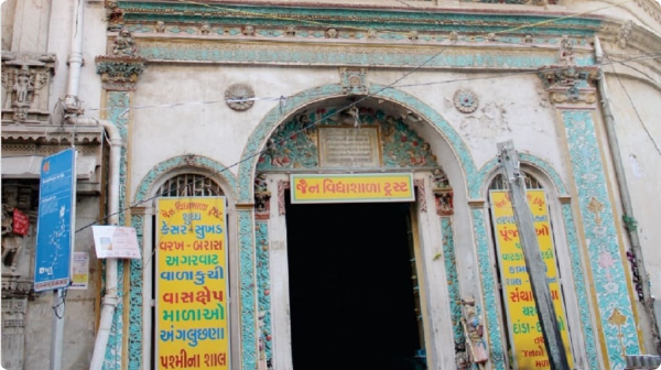 Jain temple entrance with colorful carvings and murals in Ahmedabad, India.
